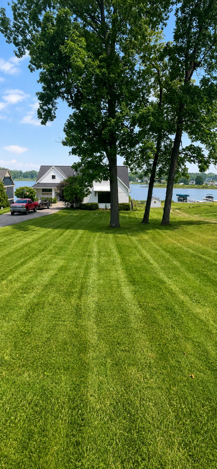 Freshly maintained lakeside lawn with visible mowing lines